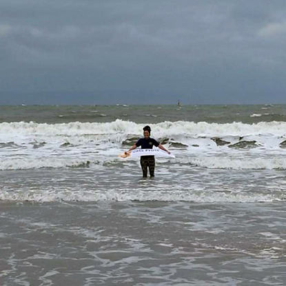 woman holding Cats Protection banner in the sea