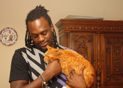 Man cuddling ginger cat in home