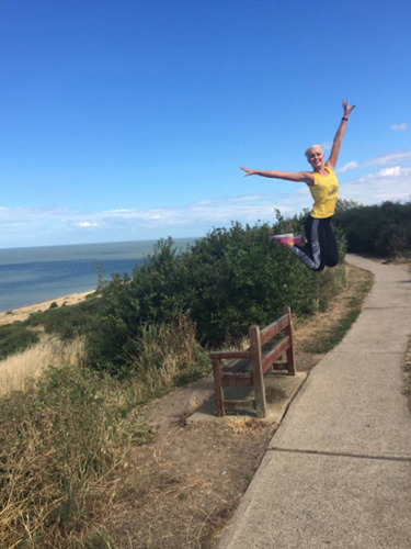 woman leaping in Cats Protection vest