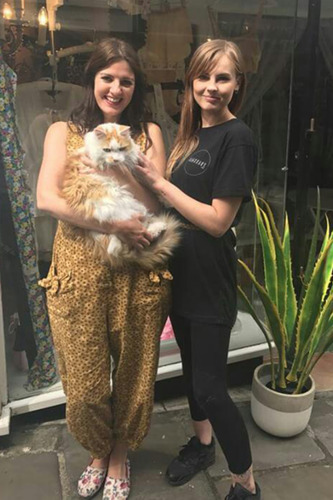 two women with longhaired white and ginger cat