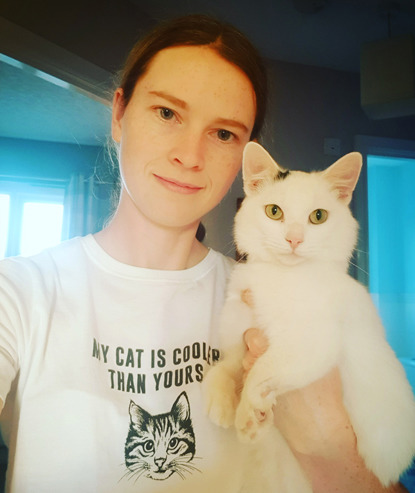 brunette woman holding white cat