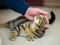 Tabby cat lying on a carpet while a hand gently strokes their head.