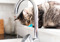 A tabby cat watching a running tap