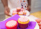Two cupcakes with a cat cake topper on one