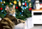 brown tabby cat with Christmas tree in the background